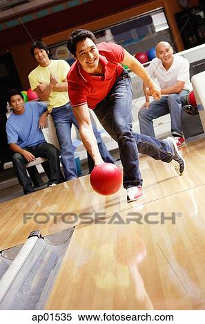 Man bowling, friends cheering in the background View Large Photo Image Stock Photography - Man bowling, friends cheering in the background. Fotosearch