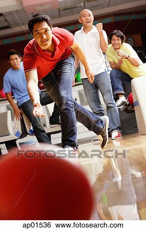 Man bowling, friends in the background, cheering View Large Photo Image Stock Photograph - Man bowling, friends in the background, cheering. Fotosearch