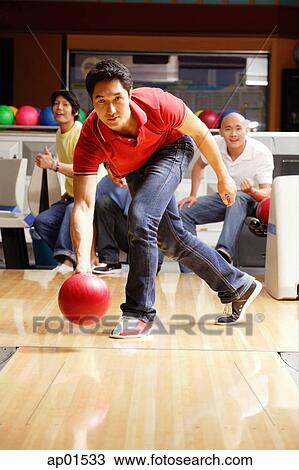 Man bowling, friends watching in the background View Large Photo Image Stock Image - Man bowling, friends watching in the background. Fotosearch