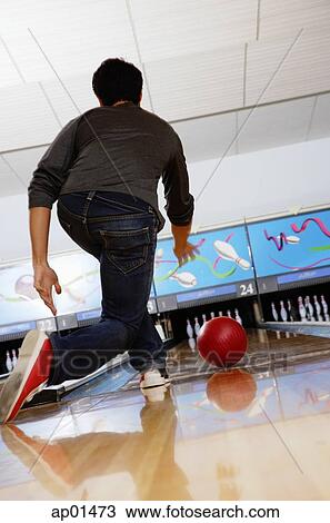 Stock Image - Man bowling in bowling alley. Fotosearch