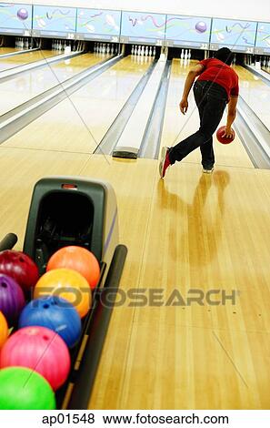 Stock Photo - Man bowling in bowling alley. Fotosearch