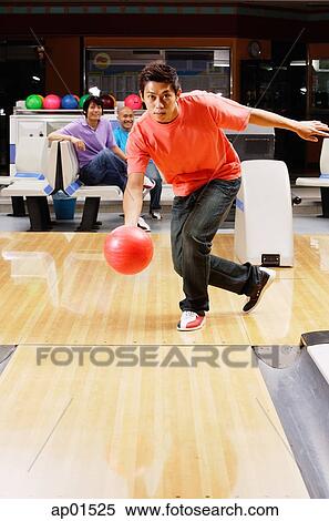 Stock Photography - Man bowling, people watching in the background. Fotosearch