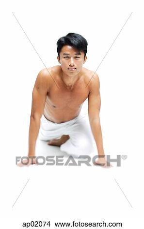 Picture - Man doing yoga, looking at camera. Fotosearch