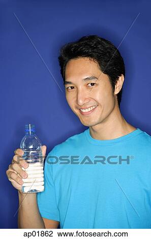 Stock Image - Man holding bottle of water. Fotosearch