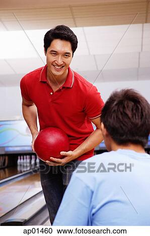 Man holding bowling ball, facing seated man View Large Photo Image Stock Image - Man holding bowling ball, facing seated man. Fotosearch