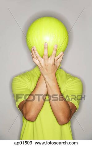Man holding bowling ball in front of his face View Large Photo Image Stock Photo - Man holding bowling ball in front of his face. Fotosearch