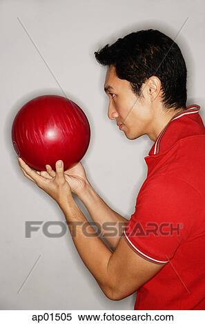 Man holding bowling ball in front of face View Large Photo Image Stock Photography - Man holding bowling ball in front of face. Fotosearch