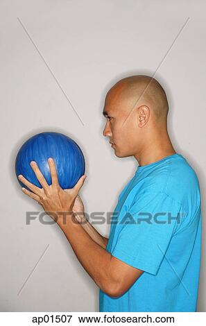 Man holding bowling ball looking away View Large Photo Image Stock Photo - Man holding bowling ball looking away. Fotosearch