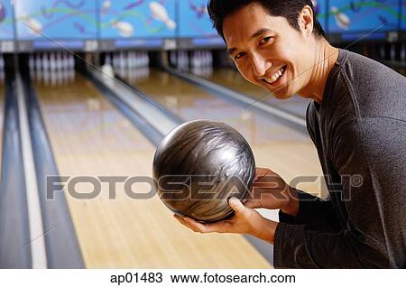 Man holding bowling ball, smiling at camera View Large Photo Image Stock Image - Man holding bowling ball, smiling at camera. Fotosearch