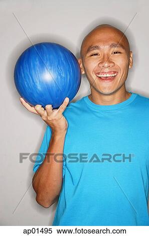 Man holding bowling ball, smiling View Large Photo Image Stock Photography - Man holding bowling ball, smiling. Fotosearch