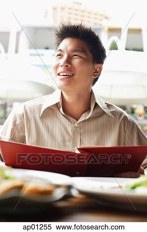 Stock Photography - Man holding menu, away. Fotosearch
