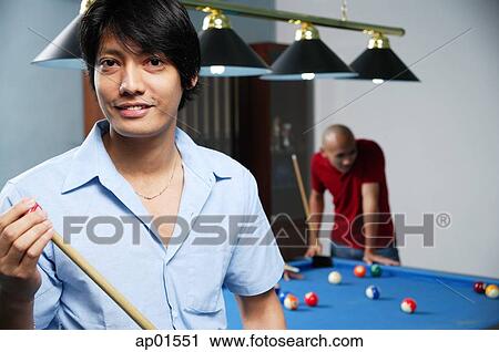 Man holding pool cue, smiling at camera View Large Photo Image Stock Image - Man holding pool cue, smiling at camera. Fotosearch