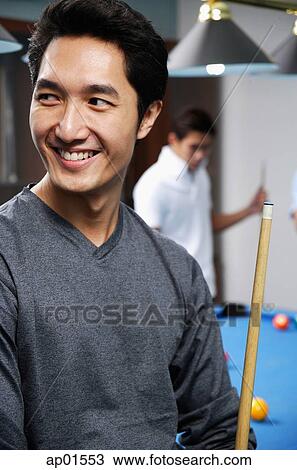 Man holding pool cue, smiling, looking away View Large Photo Image Stock Image - Man holding pool cue, smiling, looking away. Fotosearch