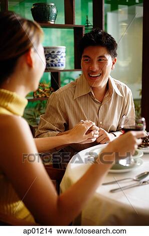 Man holding woman's hand in restaurant, ring on her finger View Large Photo Image Picture - Man holding woman's hand in restaurant, ring on her finger. Fotosearch