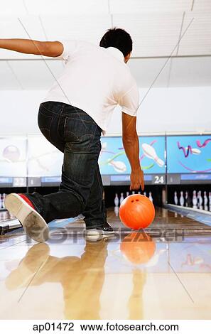 Stock Image - Man in bowling alley, rear view. Fotosearch
