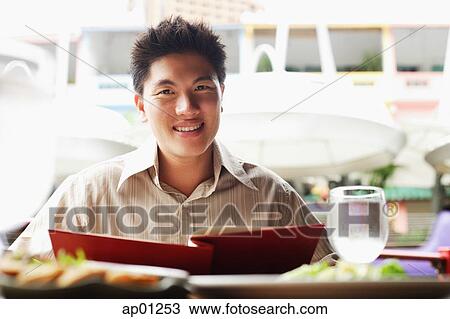 Man in cafe, holding menu, looking at camera View Large Photo Image Stock Image - Man in cafe, holding menu, looking at camera. Fotosearch