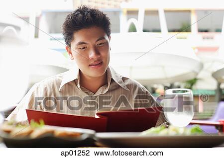 Man in cafe, looking at menu View Large Photo Image Stock Image - Man in cafe, looking at menu. Fotosearch