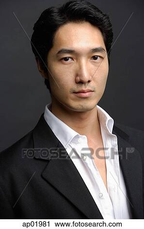 Stock Image - Man in white shirt and jacket, looking at camera. Fotosearch