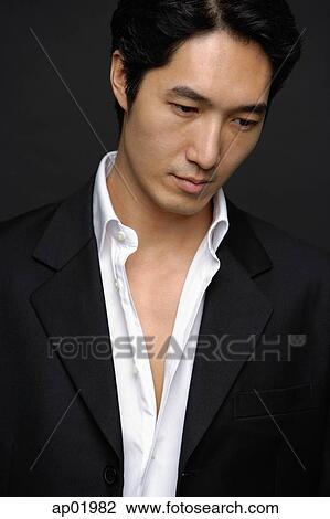 Stock Image - Man in white shirt and jacket, looking down. Fotosearch