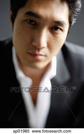 Stock Photography - Man in white shirt and jacket, looking at camera, selective focus. Fotosearch