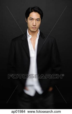 Picture - Man in white shirt and jacket, standing, looking at camera. Fotosearch