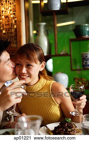 Man kissing woman on cheek in restaurant View Large Photo Image Stock Image - Man kissing woman on cheek in restaurant. Fotosearch