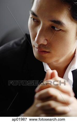 Man looking at away, hands clasped, selective focus View Large Photo Image Stock Photo - Man looking at away, hands clasped, selective focus. Fotosearch