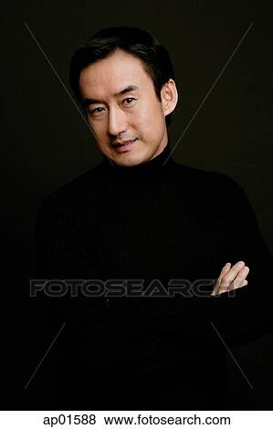 Man looking at camera, arms crossed, black background View Large Photo Image Stock Photo - Man looking at camera, arms crossed, black background. Fotosearch