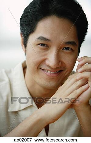 Stock Photo - Man looking at camera, smiling, portrait. Fotosearch