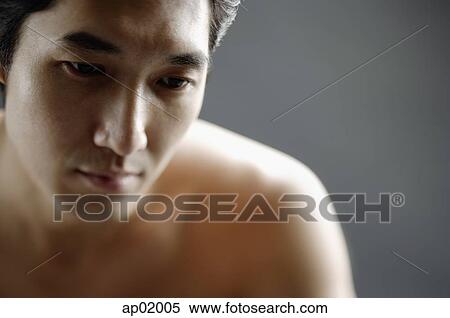 Stock Photography - Man looking down, semi-dressed, portrait. Fotosearch