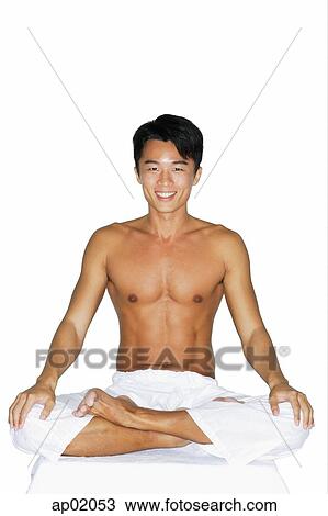 Stock Image - Man sitting in yoga position, smiling at camera. Fotosearch
