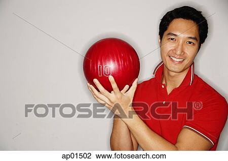 Man smiling at camera, holding bowling ball View Large Photo Image Stock Image - Man smiling at camera, holding bowling ball. Fotosearch