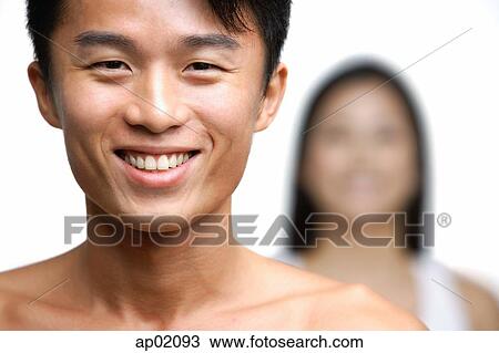 Man smiling at camera, person in the background View Large Photo Image Stock Image - Man smiling at camera, person in the background. Fotosearch