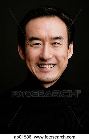 Man smiling, head shot, black background View Large Photo Image Stock Photograph - Man smiling, head shot, black background. Fotosearch