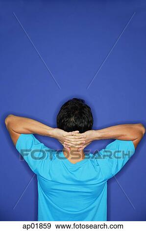 Man standing with hands behind head, rearview View Large Photo Image Stock Photo - Man standing with hands behind head, rearview. Fotosearch