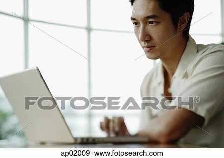 Stock Photo - Man using laptop. Fotosearch