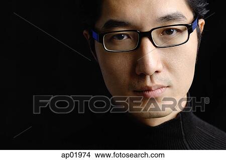 Man wearing black glasses, looking at camera View Large Photo Image Picture - Man wearing black glasses, looking at camera. Fotosearch