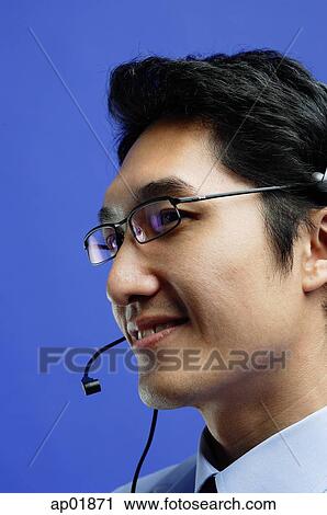 Man wearing headset, looking away, smiling View Large Photo Image Stock Image - Man wearing headset, looking away, smiling. Fotosearch