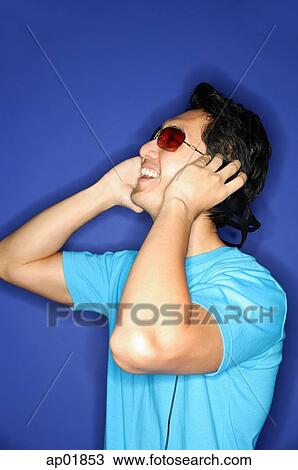 Man wearing sunglasses, wearing headphones, looking away View Large Photo Image Stock Image - Man wearing sunglasses, wearing headphones, looking away. Fotosearch