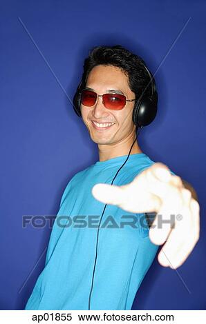 Man wearing sunglasses, wearing headphones, hand outstretched View Large Photo Image Stock Photography - Man wearing sunglasses, wearing headphones, hand outstretched. Fotosearch
