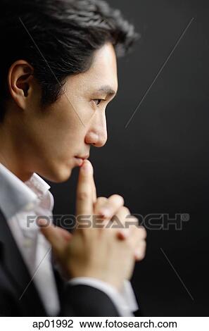 Man with clasped hands, fingers on mouth View Large Photo Image Stock Image - Man with clasped hands, fingers on mouth. Fotosearch