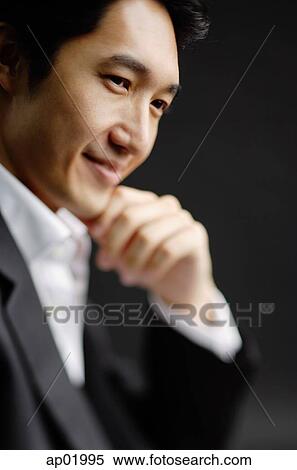 Stock Photography - Man with hand on chin, smiling. Fotosearch