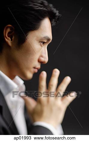 Man with hands pressed together, profile view View Large Photo Image Stock Image - Man with hands pressed together, profile view. Fotosearch