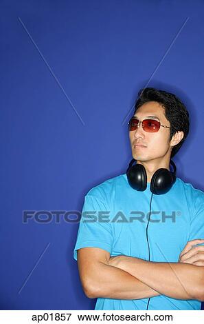 Man with headphones around his neck, arms crossed, looking away View Large Photo Image Stock Photo - Man with headphones around his neck, arms crossed, looking away. Fotosearch