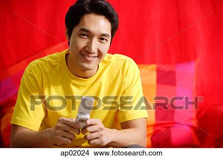Man with mobile phone, smiling at camera View Large Photo Image Picture - Man with mobile phone, smiling at camera. Fotosearch