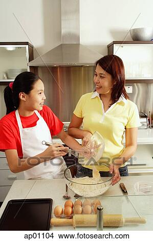 Mother and daughter in kitchen, preparing ingredients for baking View Large Photo Image Picture - Mother and daughter in kitchen, preparing ingredients for baking. Fotosearch