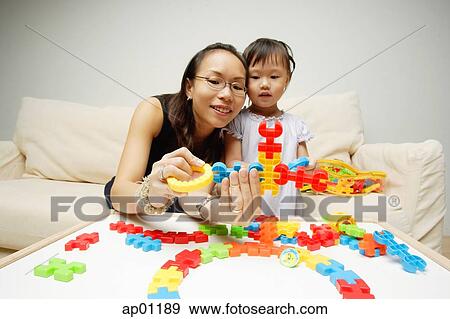 Mother and daughter looking at toy pieces View Large Photo Image Stock Photo - Mother and daughter looking at toy pieces. Fotosearch