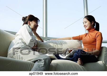 Mother and daughter sitting face to face on sofa View Large Photo Image Stock Photo - Mother and daughter sitting face to face on sofa. Fotosearch