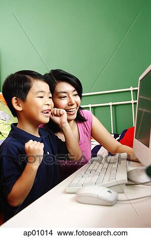 Mother and son looking at computer, smiling View Large Photo Image Picture - Mother and son looking at computer, smiling. Fotosearch