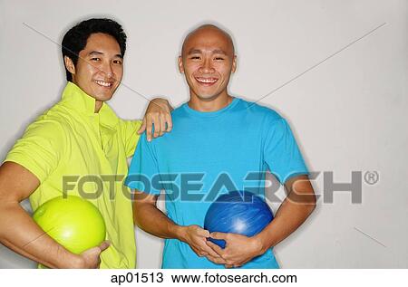 Two men holding bowling balls, smiling at camera View Large Photo Image Stock Image - Two men holding bowling balls, smiling at camera. Fotosearch